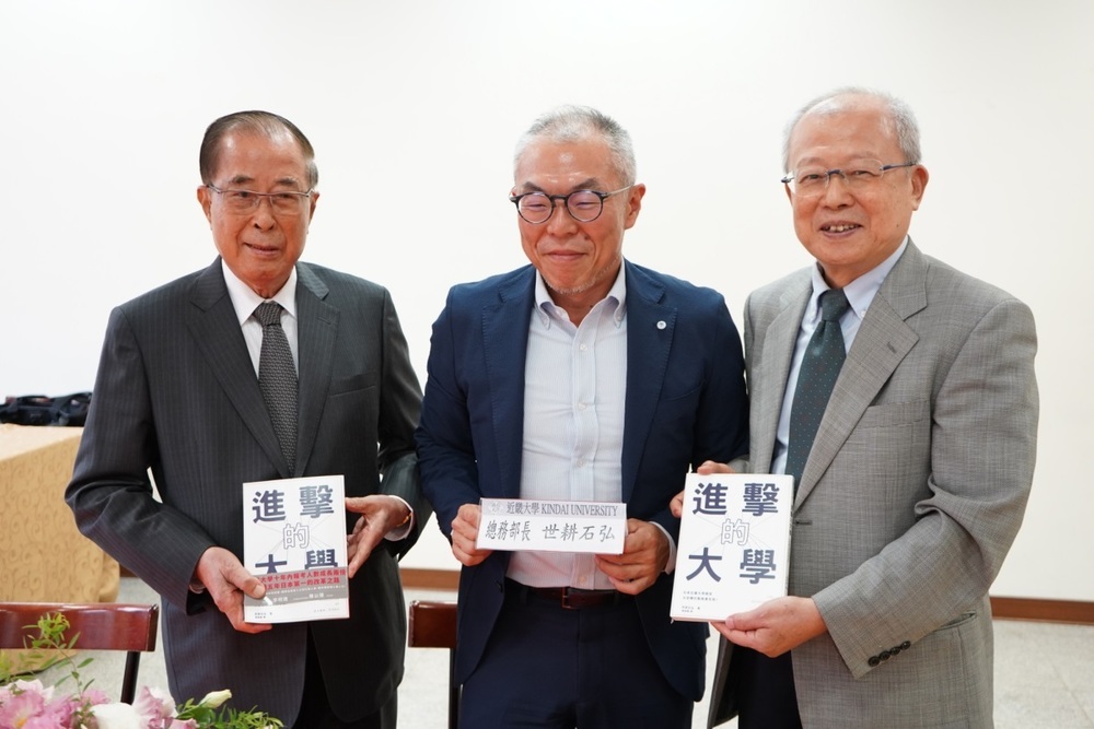 世耕石弘總務部長與創辦人、董事長於簽書會中合影。圖片