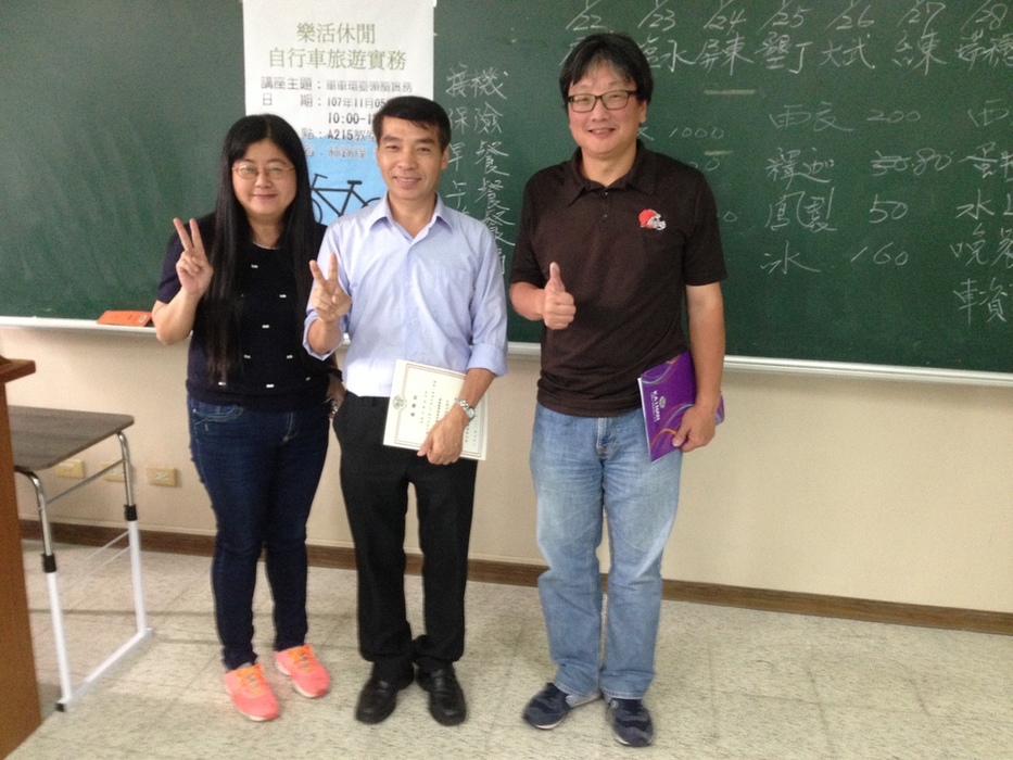 師長與講師合照，黑板上文字是講師引導學生進行單車環台預算之計算。圖片